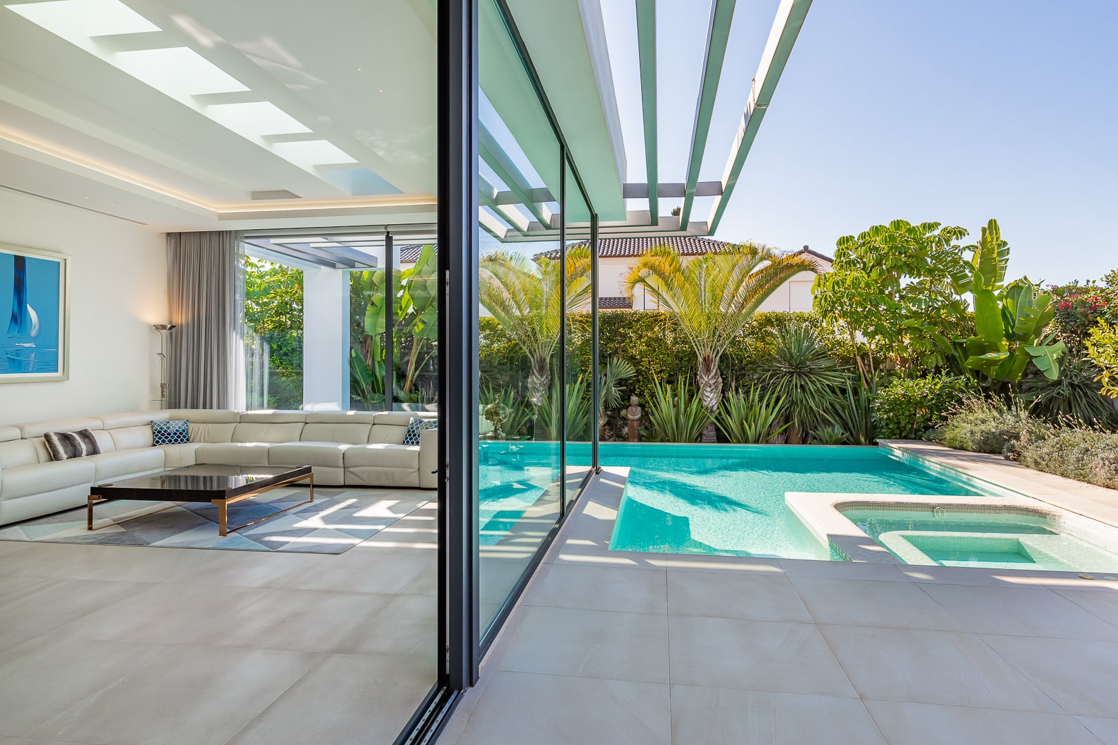 Palm tree casting reflections onto poolside glass