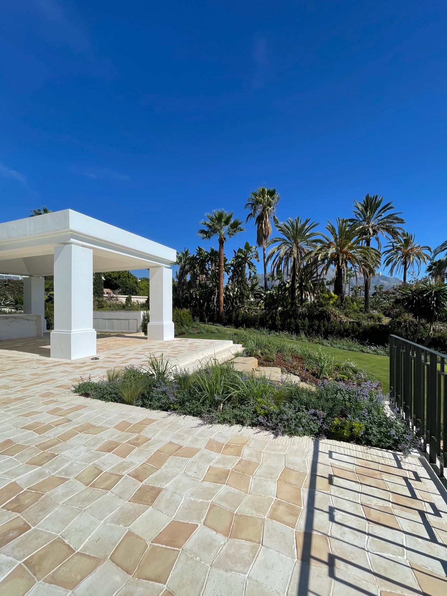 Andalusian roof tiles and terrace framing blue Marbella skies