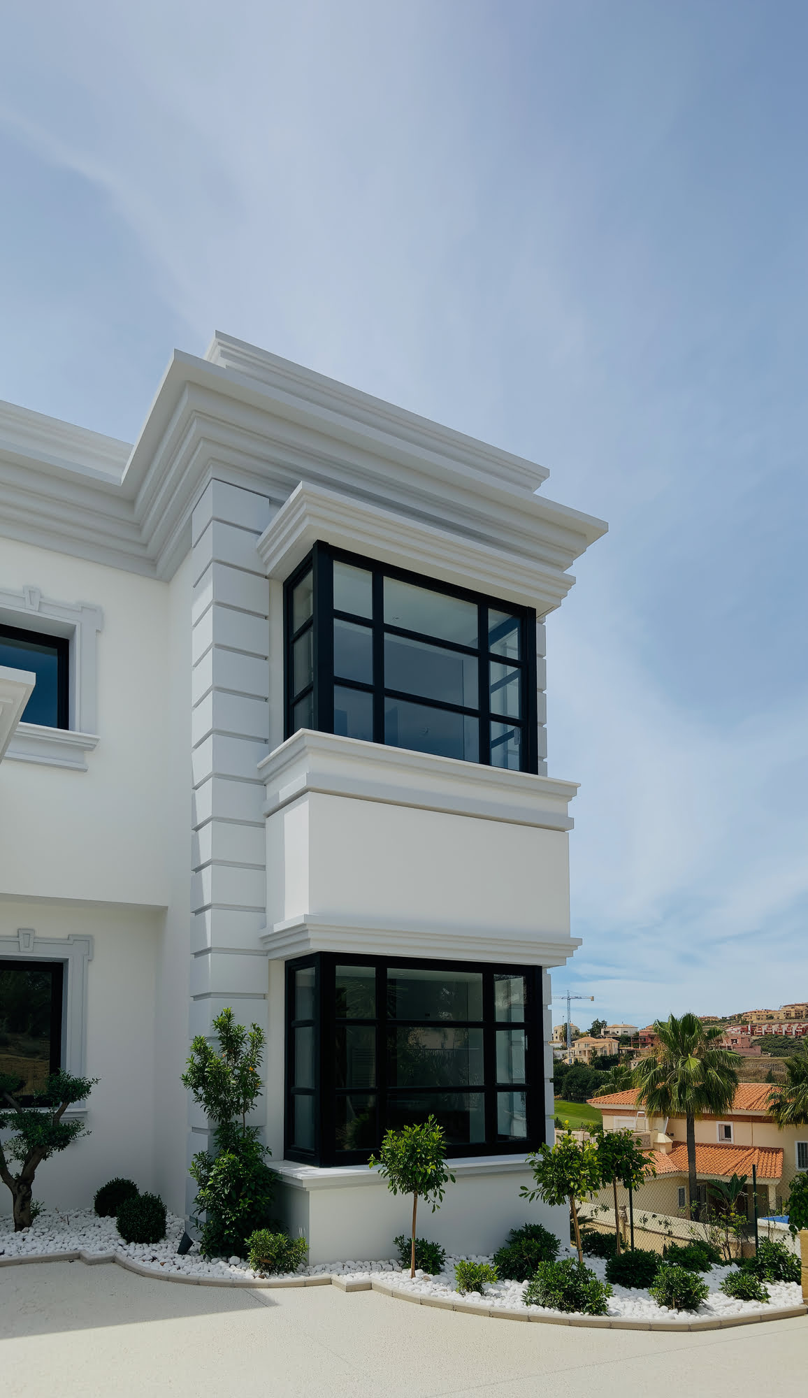 Column-framed upper balconies with black wrought iron