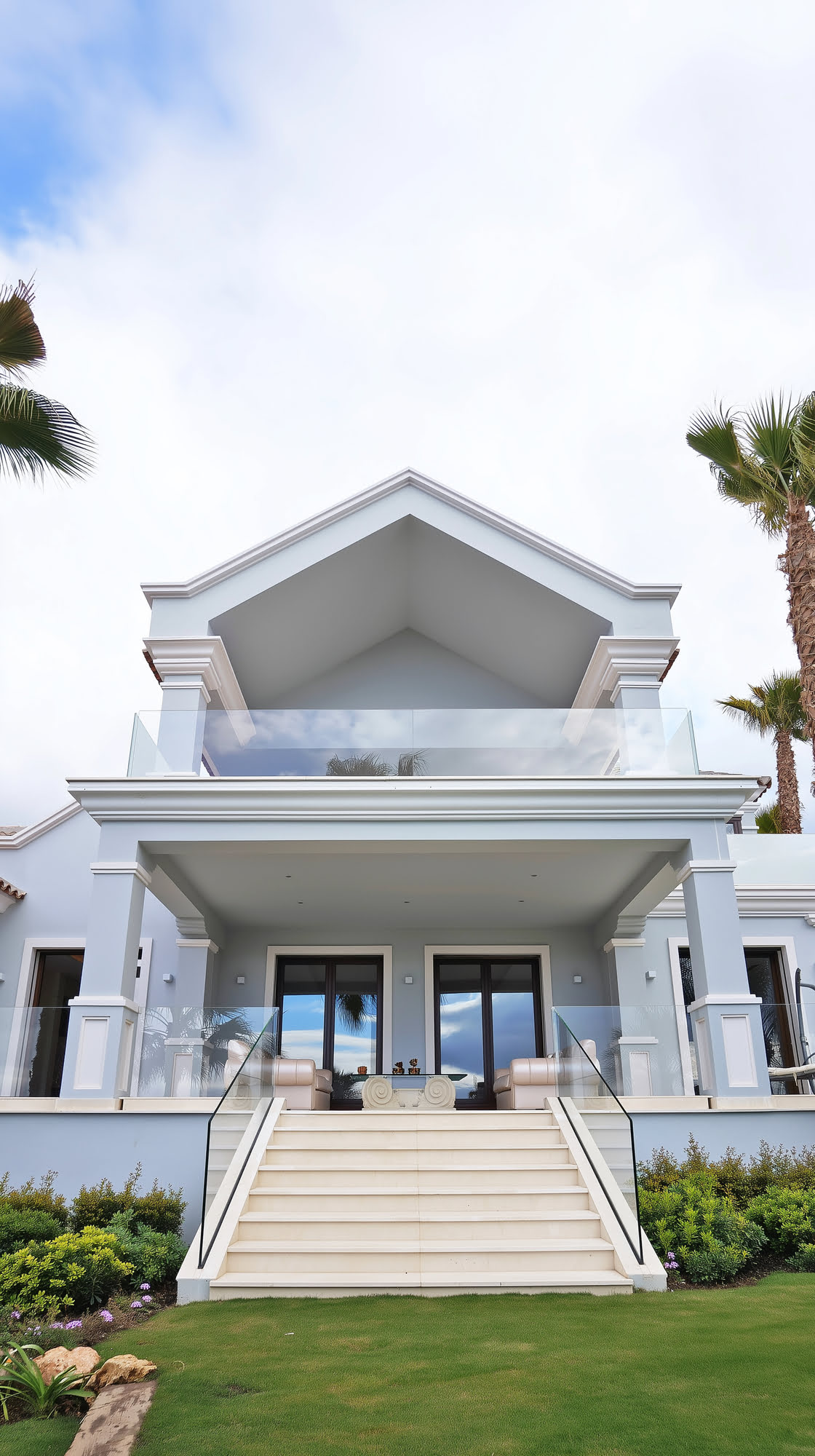 View of symmetrical façade with white columns and clay-tile roof