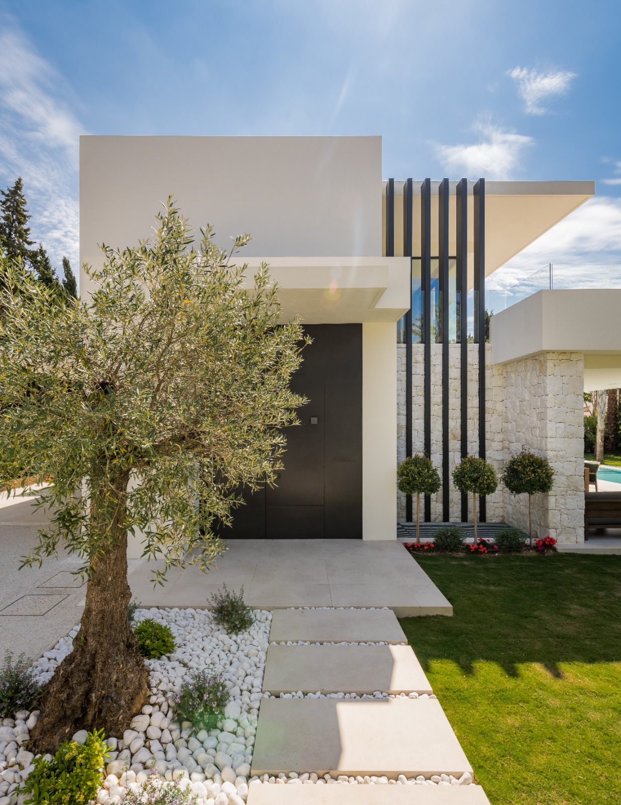 Panoramic glazing and minimal stone accents in the main facade